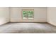 Spacious bedroom featuring soft carpet, neutral walls, and a window with lush greenery view at 1492 Station Ridge Ct, Lawrenceville, GA 30045