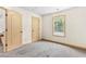 A cozy bedroom features neutral carpet, a window with natural light, and a door to another room at 1492 Station Ridge Ct, Lawrenceville, GA 30045