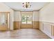 This formal light filled living room features luxury vinyl plank flooring, wall paneling and a modern chandelier at 1492 Station Ridge Ct, Lawrenceville, GA 30045