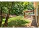 View of the backyard, featuring a wooden deck, lawn, and mature trees at 2102 Berryhill Se Cir, Smyrna, GA 30082