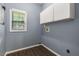 Functional laundry room with storage cabinets, gray paint, and luxury vinyl plank flooring at 2102 Berryhill Se Cir, Smyrna, GA 30082