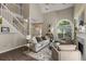 Cozy living room with fireplace, large arched window, and staircase at 2102 Berryhill Se Cir, Smyrna, GA 30082