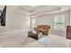 Comfortable living room featuring tray ceilings, neutral carpet, and a plush brown sofa by sunny windows at 2619 Dayview Ln, Atlanta, GA 30331