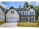 Charming two-story home featuring white brick, dark accents, a two-car garage, and a welcoming front porch at 841 Keystone Dr, Woodstock, GA 30188