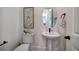 Elegant powder room with pedestal sink and decorative mirror at 841 Keystone Dr, Woodstock, GA 30188