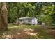 A quaint single-story home nestled among mature trees on a spacious lot at 303 Nottingham Dr, Woodstock, GA 30188