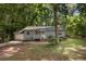 Single-story home with a welcoming front porch and mature trees surrounding the property at 303 Nottingham Dr, Woodstock, GA 30188