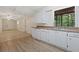 Bright kitchen features white cabinetry, stone countertops and a large window with wooded views at 303 Nottingham Dr, Woodstock, GA 30188