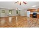 Large living area featuring wood floors, ceiling fans, and an adjacent kitchen with appliances at 303 Nottingham Dr, Woodstock, GA 30188