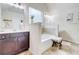 Bright bathroom with a soaking tub, tiled floors, and dark wood vanity at 312 Sierra Ct, Mcdonough, GA 30253