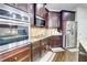 Modern kitchen with stainless steel oven, refrigerator, dark wood cabinets, and granite countertops at 312 Sierra Ct, Mcdonough, GA 30253