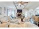 Inviting living room featuring a stone fireplace, ceiling fan and lots of natural light at 312 Sierra Ct, Mcdonough, GA 30253