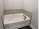 A clean and simple bathtub in the corner of the bathroom at 3402 Milan Ct, Douglasville, GA 30135