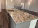 Kitchen with a large island with granite countertops and stainless steel sink at 3402 Milan Ct, Douglasville, GA 30135