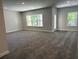 Open concept living room with natural light, carpet, and two windows at 3402 Milan Ct, Douglasville, GA 30135