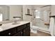 Well-lit bathroom features a granite countertop, dark cabinetry and a accessible walk-in shower at 5640 Hammock Way, Cumming, GA 30028