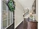 Inviting foyer with hardwood floors and elegant staircase, plus decorative plants and hanging wreath at 5640 Hammock Way, Cumming, GA 30028