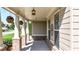 Covered front porch featuring decorative hanging plants and brick-based columns at 5640 Hammock Way, Cumming, GA 30028