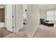 View from a hallway to a full bathroom and bedroom with chair, bed and windows at 5640 Hammock Way, Cumming, GA 30028
