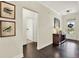 Bright hallway featuring hardwood floors, and a small side table with an entryway to another room at 5640 Hammock Way, Cumming, GA 30028