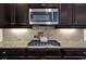 Kitchen featuring granite countertops, stainless steel appliances and dark wood cabinetry at 5640 Hammock Way, Cumming, GA 30028