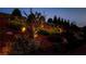 Professionally landscaped hillside backyard featuring lighting and retaining walls with greenery at 5640 Hammock Way, Cumming, GA 30028