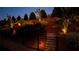 Landscaped yard featuring professional lighting, retaining wall and stairs to the back, with a fence at 5640 Hammock Way, Cumming, GA 30028