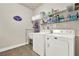 Well-organized laundry room featuring a washer, dryer, utility sink, and ample shelving for storage at 5640 Hammock Way, Cumming, GA 30028