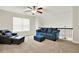 Upstairs living room with plush blue seating, ceiling fan, and sun-drenched window perfect for relaxation and entertainment at 5640 Hammock Way, Cumming, GA 30028