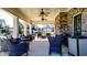 Covered patio with comfortable seating, ceiling fans, and a stone accent wall at 5640 Hammock Way, Cumming, GA 30028