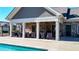 Relaxing poolside featuring ample seating and a covered patio with stone accents at 5640 Hammock Way, Cumming, GA 30028