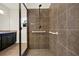 Bathroom with large shower featuring tiled walls, glass door, and grab bars at 5640 Hammock Way, Cumming, GA 30028