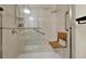 Accessible walk-in shower features grab bars and a fold down wooden bench seat at 5640 Hammock Way, Cumming, GA 30028
