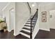 Staircase features hardwood treads, black iron balusters, and white risers at 5640 Hammock Way, Cumming, GA 30028