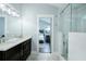 Bathroom featuring a double sink vanity, modern fixtures, and a glass-enclosed shower with a seat at 787 Mckendree Lake Way, Lawrenceville, GA 30043