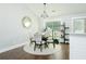 Well-lit dining room with an elegant chandelier, a modern dining table, and a large window at 787 Mckendree Lake Way, Lawrenceville, GA 30043
