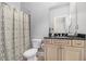 Well-lit bathroom with tiled floors, patterned shower curtain, and granite vanity at 1836 Preserve Way, Brookhaven, GA 30341