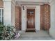 Charming brick-accented entryway with a wood front door and welcoming welcome mat at 1836 Preserve Way, Brookhaven, GA 30341