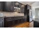 Modern kitchen with stainless steel appliances, dark cabinetry, granite countertops, and hardwood floors at 1836 Preserve Way, Brookhaven, GA 30341