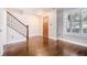 Foyer featuring hardwood floors, a staircase with metal railing, and natural light streaming through shuttered window at 1836 Preserve Way, Brookhaven, GA 30341