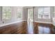 Spacious living room with hardwood floors, three windows, and sliding doors to outdoor deck at 1836 Preserve Way, Brookhaven, GA 30341