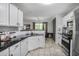 Bright kitchen with white cabinets, black countertops, stainless steel appliances, and tile backsplash at 306 Overbend Sw Lndg, Marietta, GA 30008