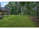 Back yard features mature trees for privacy and lush green grass at 397 Lovejoy Cir, Powder Springs, GA 30127