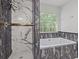A modern bathroom features a stylish shower and tub with elegant marble tiling, complemented by a bright window at 397 Lovejoy Cir, Powder Springs, GA 30127