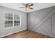 Bright bedroom with a feature wall, a ceiling fan, and a large window with natural light at 397 Lovejoy Cir, Powder Springs, GA 30127