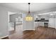 Open-concept dining area flows into the kitchen, featuring hardwood floors and modern lighting at 397 Lovejoy Cir, Powder Springs, GA 30127
