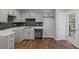 Charming kitchen with wood floors, grey cabinets, modern backsplash, and natural light at 397 Lovejoy Cir, Powder Springs, GA 30127