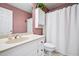 Quaint bathroom with pink wallpaper, a white vanity, toilet, and a patterned shower curtain at 5427 Trentham Dr, Atlanta, GA 30338