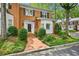 Charming brick townhome featuring lush landscaping and a welcoming brick pathway to the front door at 5427 Trentham Dr, Atlanta, GA 30338