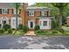 Traditional brick townhome with manicured landscaping, black shutters, and inviting curb appeal at 5427 Trentham Dr, Atlanta, GA 30338